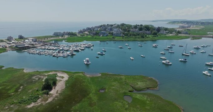 Drone flying over bay with houses and sailboats in scituate at us east coast