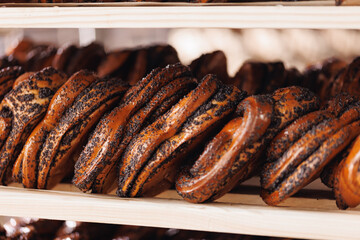 Closeup Buns with poppy seeds. Different types of artisan craft bread in bakery store shelves