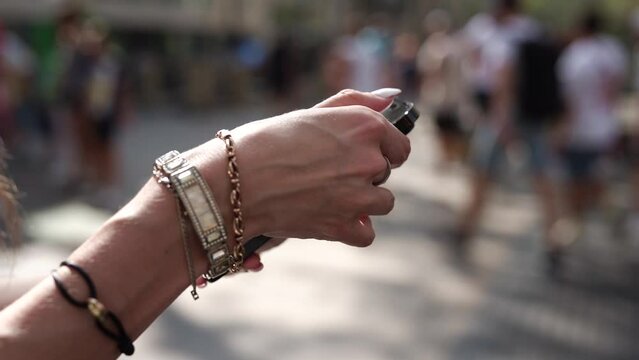 A girl on the street in her hands holds a black iPhone 14 pro max close-up.