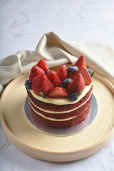 freshly handmade beautiful wedding birthday ice cream cake red velvet w strawberry blueberry fruit on white marble luxury background with wood plate flower decoration halal food dessert menu for cafe