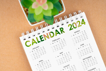 The 12 months desk calendar 2024 on brown background.