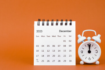 The December 2023 Monthly desk calendar for 2023 year and alarm clock