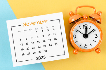 Fototapeta na wymiar The November 2023 Monthly calendar for 2023 year with alarm clock on beautiful background.