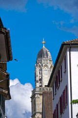 Obraz premium Alley at the old town of City of Zürich with church tower of Great Minster church in the background on a sunny summer noon. Photo taken August 5th, 2023, Zurich, Switzerland.