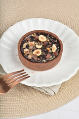 freshly handmade beautiful France rocher dark chocolate layer tart w mixed macadamia peanuts on white marble luxury background with bamboo decoration halal food dessert menu for cafe