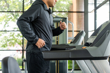 Fototapeta na wymiar Male runner exercise indoor gym. fitness man jogging wearing sportswear. Workout and healthy Young athlete running on the treadmill.