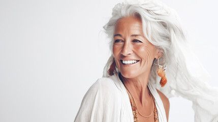 Portrait of a smiling woman in her 70s on a white background. Lifestyle.
