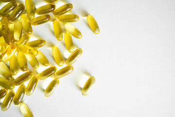 Fish oil capsules, omega 3, on white surface. Oil filled capsules, softgel of food supplements.