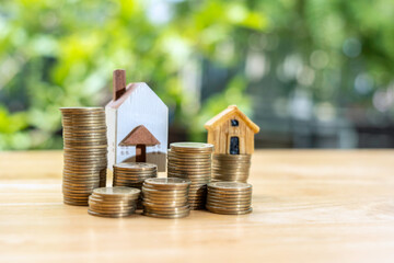 Coins stack in front of wooden home on wooden table, Save money concept, Property investment, house loan, reverse mortgage, gold coins money stack growth, saving money coins stack future for home