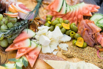 A closeup shot of a gourmet charcuterie board with meats and fruits