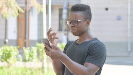 Outdoor Portrait of Upset African American Man get Shocked on Smartphone