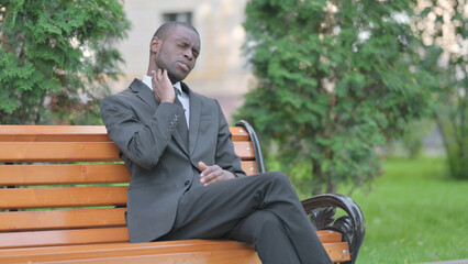 Obraz premium Tired African Businessman Sitting Outdoor with Neck Pain