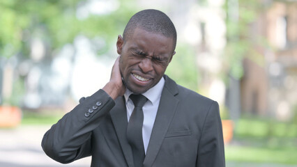 Outdoor Portrait of Tired African Businessman with Neck Pain