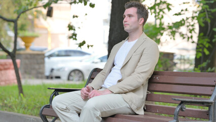 Obraz premium Casual Young Man Coming and Sitting on Bench