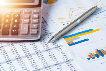 Pen and Calculator on business data report, sales statistics chart or graph. Business or financial concept. - obrazy, fototapety, plakaty