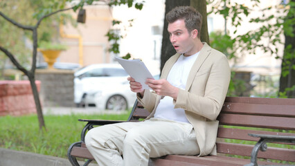 Casual Young Man Feeling Upset while Reading Contract Outdoor