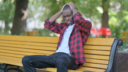 Worried Young African Man Sitting Outdoor Feeling Scared and Afraid