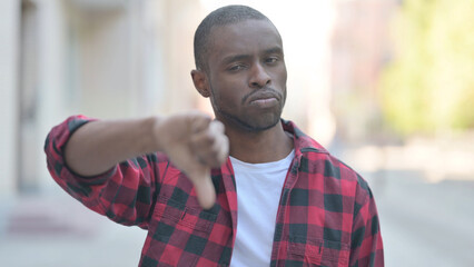 Outdoor Portrait of Young African Man Doing Thumbs Down