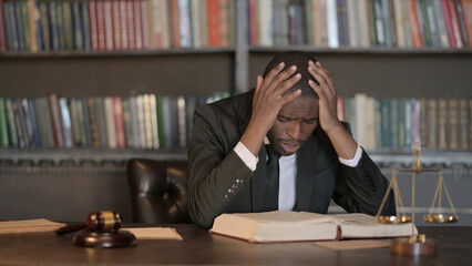 Upset African Male Lawyer Reading Law Book in Office