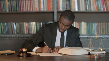 Fototapeta premium Pensive African Male Lawyer Reading Law Book, Preparing for Court