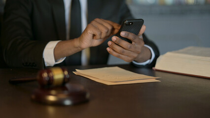 Close Up of African Judge using Smartphone in Court