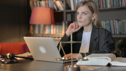 Pensive Female Lawyer Working on Laptop