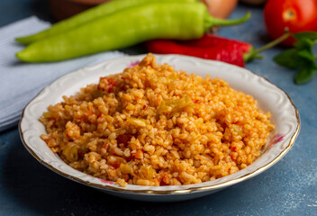 Traditional turkish bulgur pilaf with tomato sause in plate (Turkish name; meyhane pilavi)