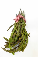 Closeup of a bunch of fresh green asparagus spears on a white background