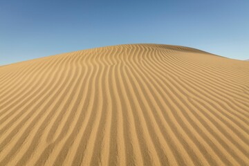 Vast expanse of golden sand with a deep blue sky in the background