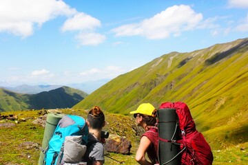 Adult women with backpacks hiking on a sunny day in Georgia