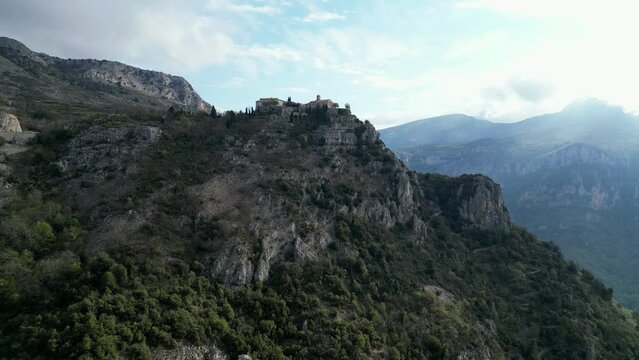Drone footage over mountain top village Gourdon in Provence, France with cloudy sky