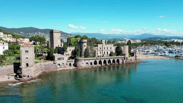 Drone footage over the sea and stone Chateau de la 
Castle in Mandelieu-La Napoule, France