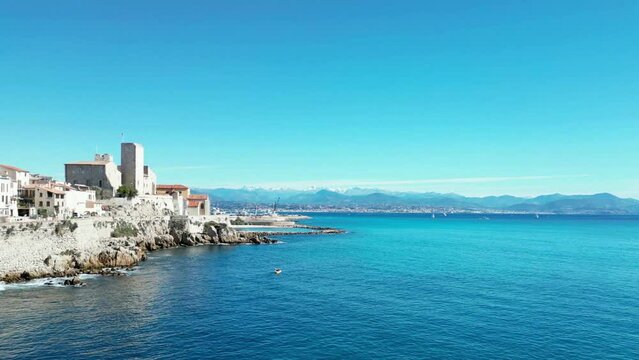 Aerial of the white buildings of Brindisi city in Italy alongside the blue sea
