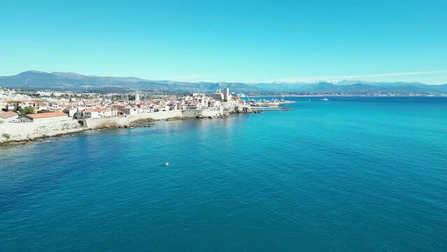 Aerial of the white buildings of Brindisi city in Italy alongside the blue sea