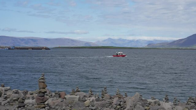 Small red boat in Faxafloi bay in Reykjavik, Iceland
