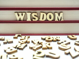 Closeup of the word WISDOM written with wooden letters on a board