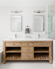 A cozy bathroom detail with a white oak vanity cabinet, white countertop, bronze faucets and lights...