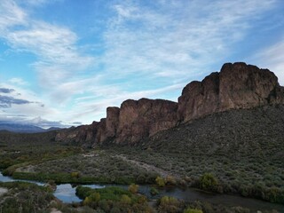 Flowing water surrounded by cliffs and a landscape covered with bushes