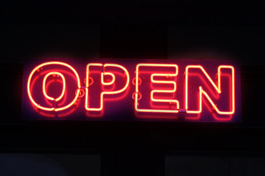 Red neon "Open" sign against the black background