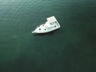 Aerial shot of a boat sailing in tranquil waters on a placid lake.