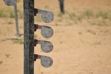 Targets at a shooting range set up in a desolate outdoor area illuminated by bright sunlight