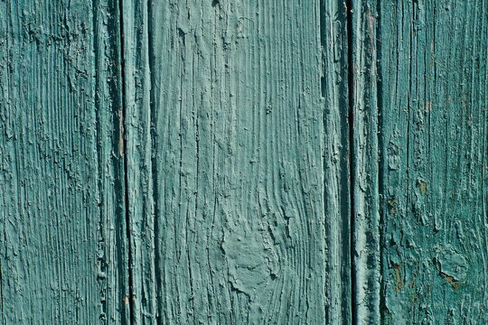old green painted wooden texture of vertical wooden boards of the wall of an old house on the street