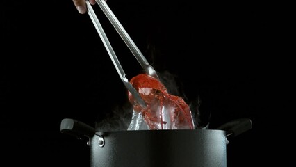 Taking boiling lobster out of pot in super slow motion.