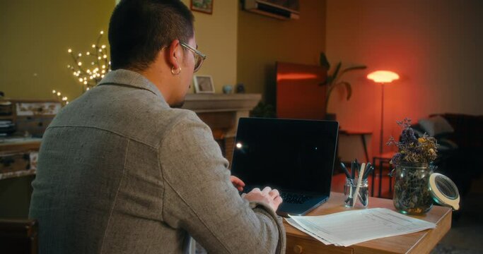 Overworked freelancer using laptop computer at night tp meet a deadline