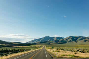Beautiful road landscape with road signs, mountains, highway and blue sky with fluffy clouds on a...