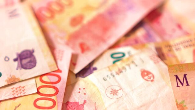 Lots of argentine pesos bills mixed in one thousand and five hundred bills