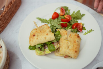 Healthy chicken and spinach sandwiches and fresh vegetable salad on the table at city cafe. Healthy diet food concept. for breakfast or lunch. Vegetarian food. Vegan menu. Long banner format. High