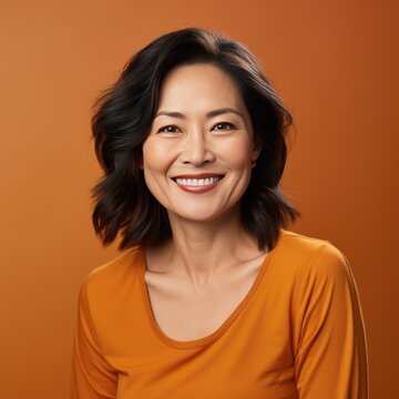 Portrait of a Middle Aged Asian Woman Headshot on a Orange Background 