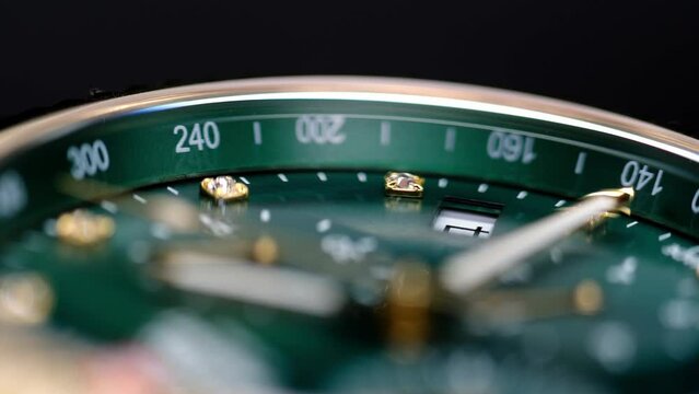 Close Up Of Stylish Luxury Man Wrist Watch With Moving Hand And Multiple Dials. Men's chronograph watch in metal with sapphire crystal. closeup view of rotating watch, running second arrow. green dial