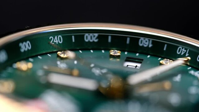 Close Up Of Stylish Luxury Man Wrist Watch With Moving Hand And Multiple Dials. Men's chronograph watch in metal with sapphire crystal. closeup view of rotating watch, running second arrow. green dial